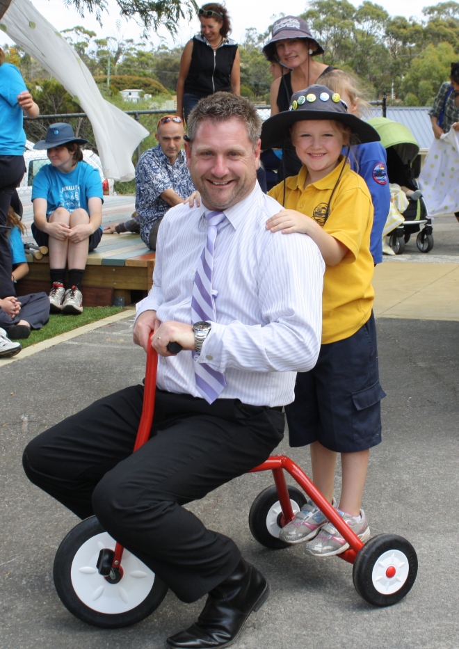 Principal Matt Kenny with his  red tricycle in the new kinder playground. 